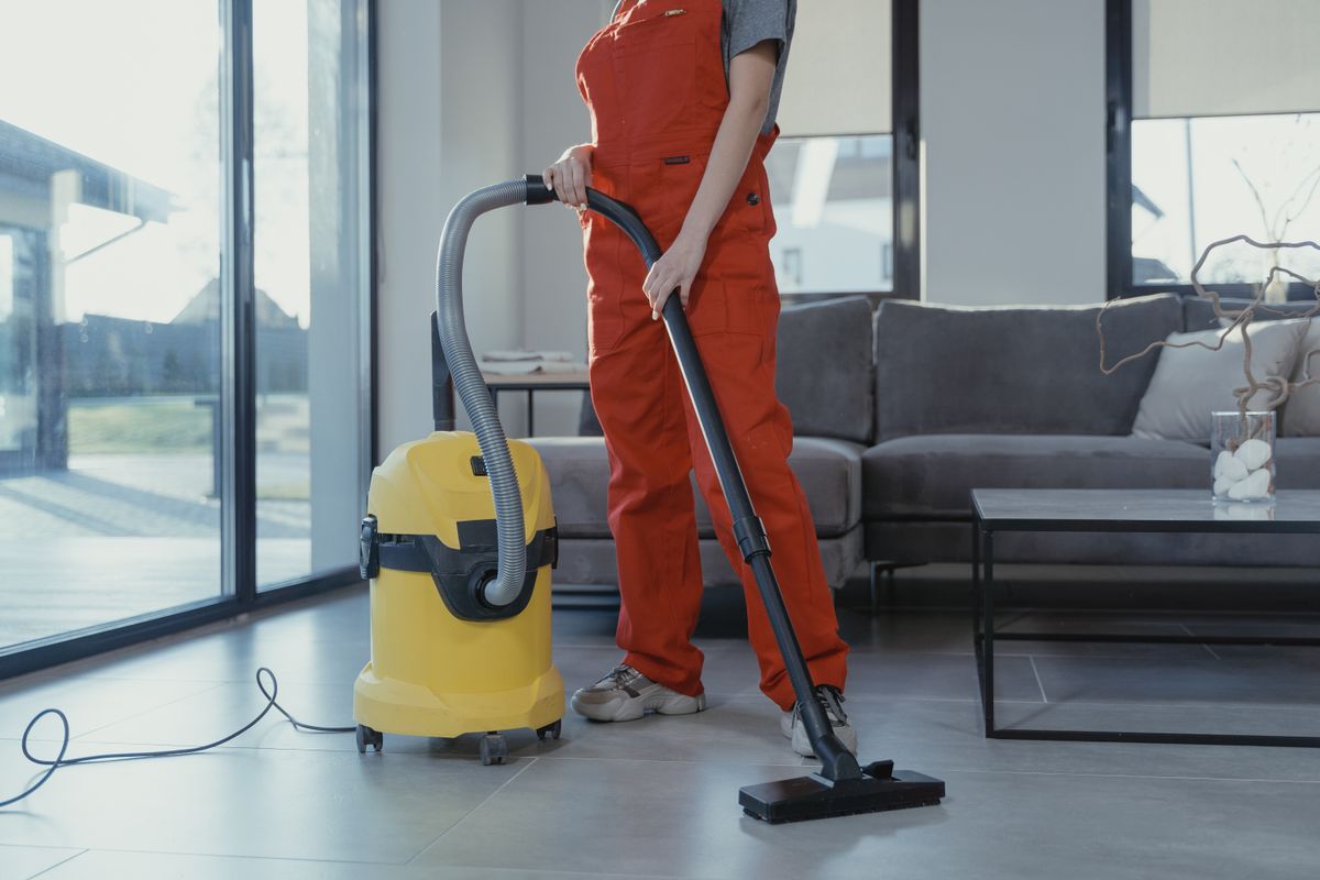 Professional cleaner vacuuming a Rhode Island living room