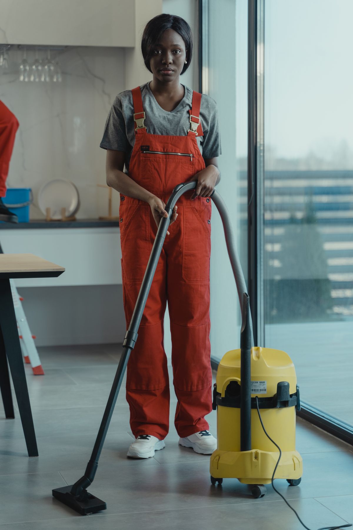 Cleaner vacuuming a bright modern home during a standard cleaning